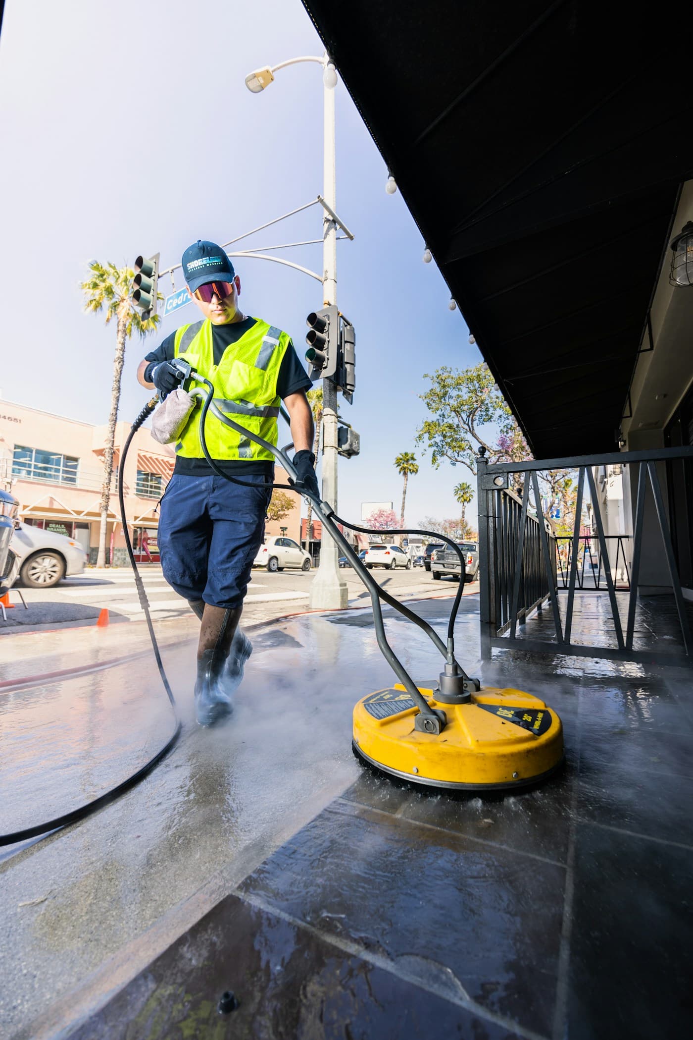 Worker power washing a surface with a pressure cleaner