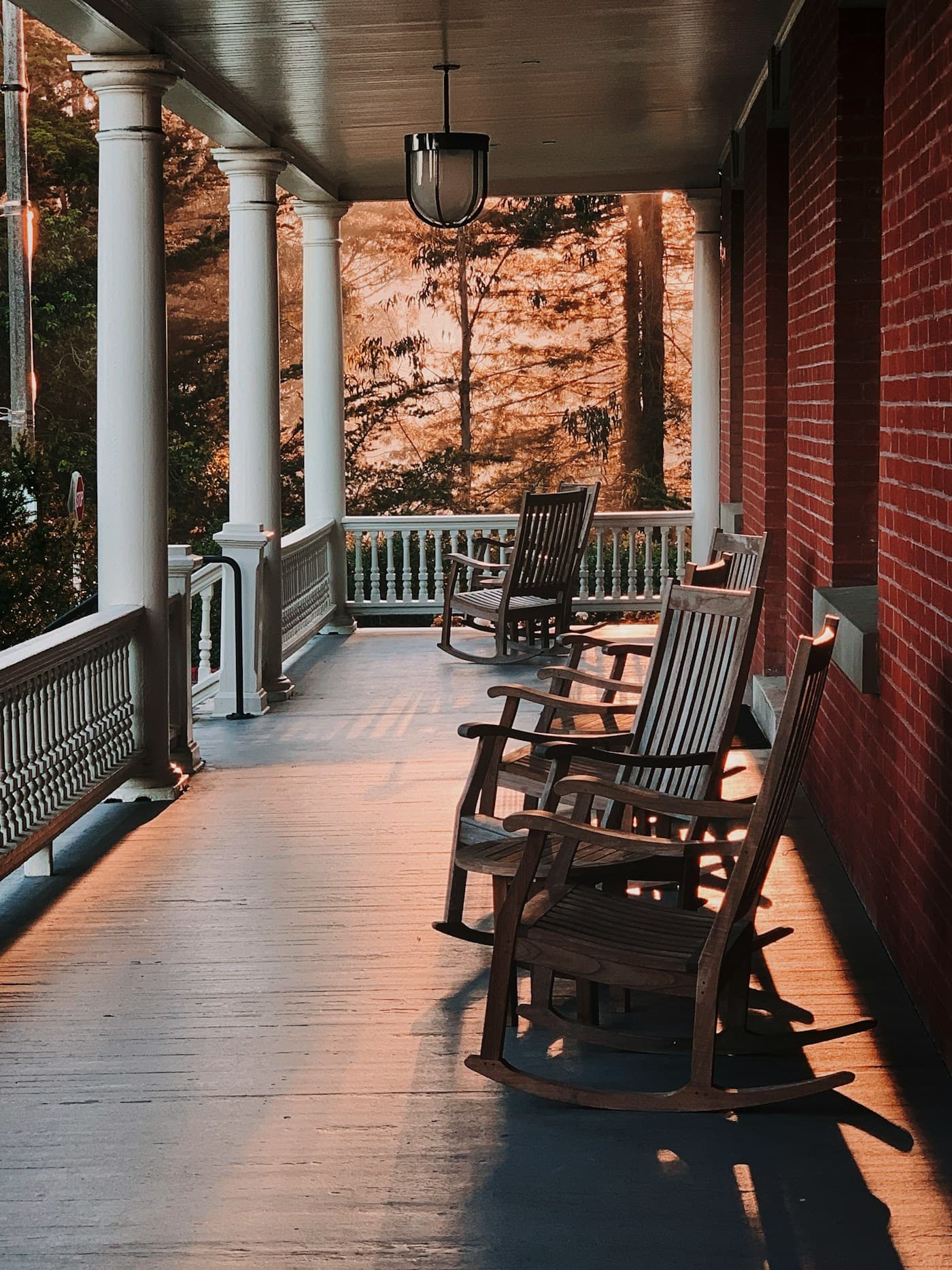 A welcoming front porch with rocking chairs in warm evening light